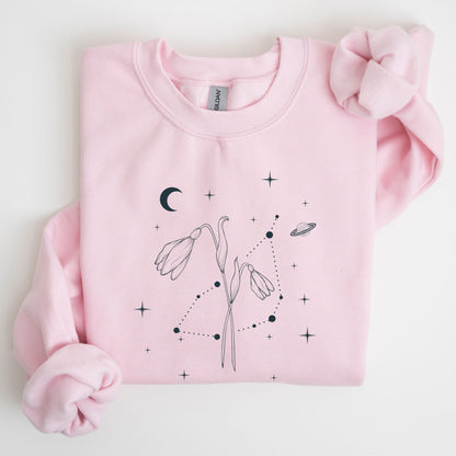 Pink sweatshirt with celestial design on a light gray background