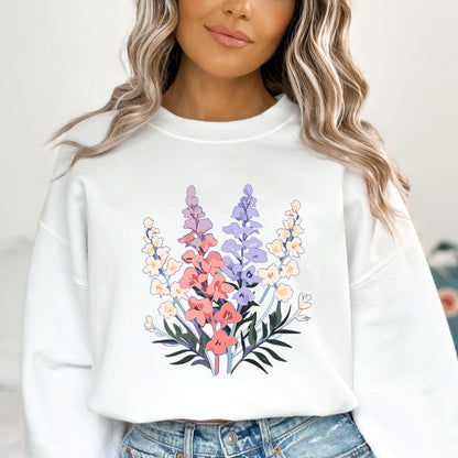Person wearing a white sweatshirt with a floral design on a plain background
