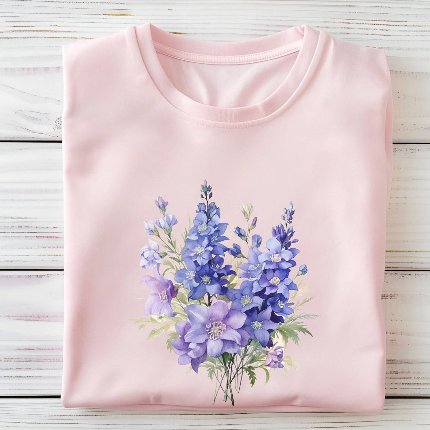 Pink t-shirt with a floral design on a wooden surface