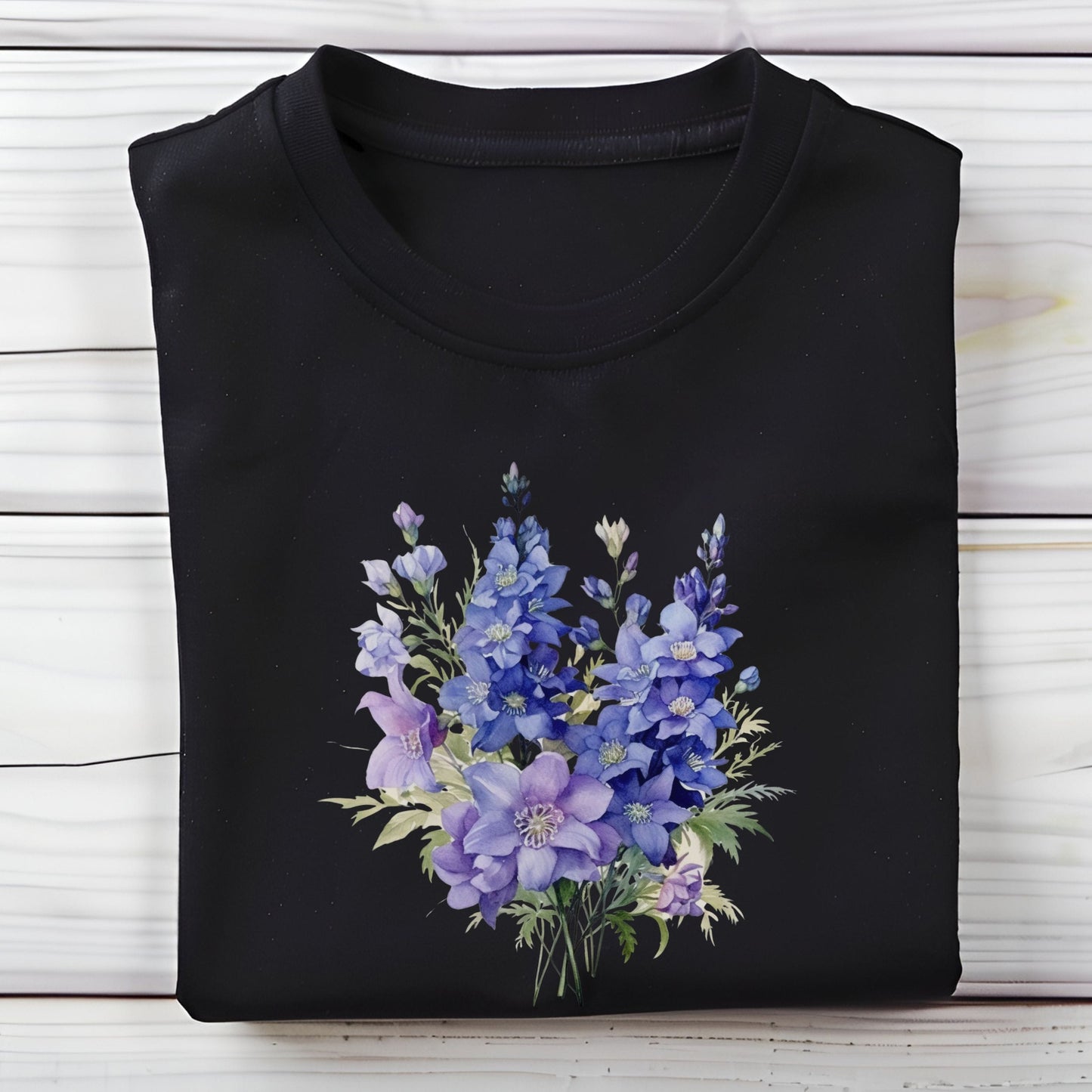Black t-shirt with a blue floral design on a wooden surface