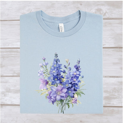 Light blue t-shirt with a purple floral design on a wooden surface