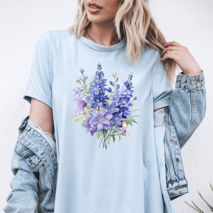 Person wearing a light blue t-shirt with a floral design, paired with a denim jacket.