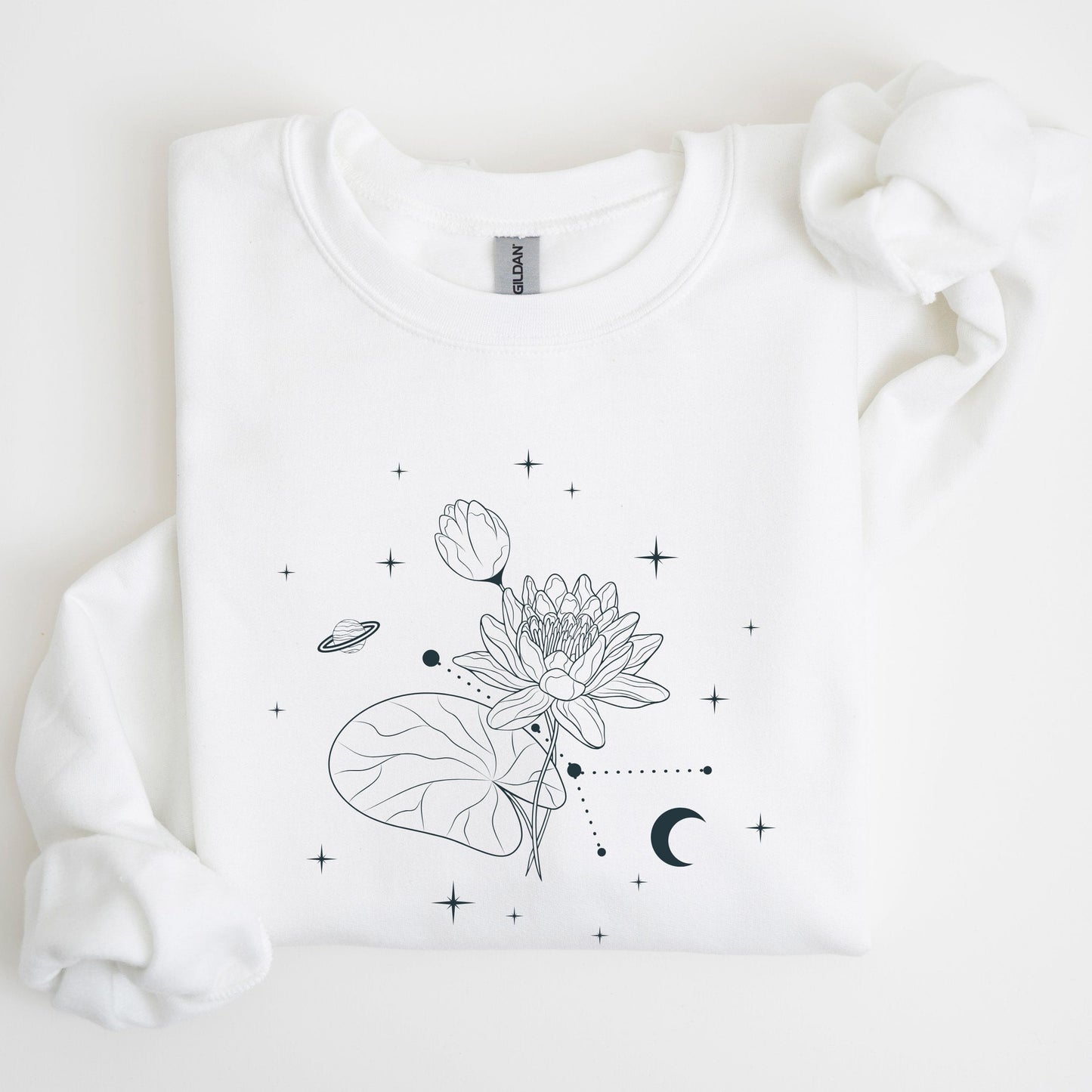 White sweatshirt with black floral and celestial design on a light background