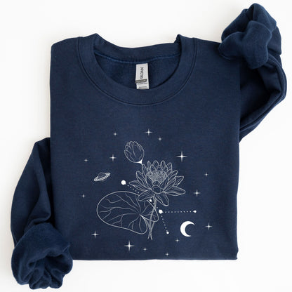 Folded navy blue sweatshirt with white floral and celestial design on a white background