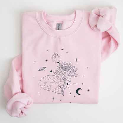 Pink sweatshirt with black floral and celestial design on a light gray background