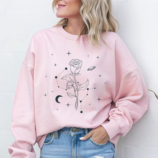 Person wearing a pink sweatshirt with floral and celestial design against a white background