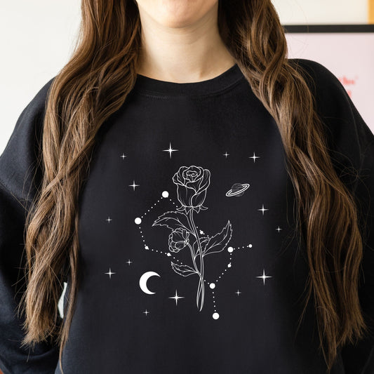 Person wearing a black sweatshirt with a white rose and moon design.