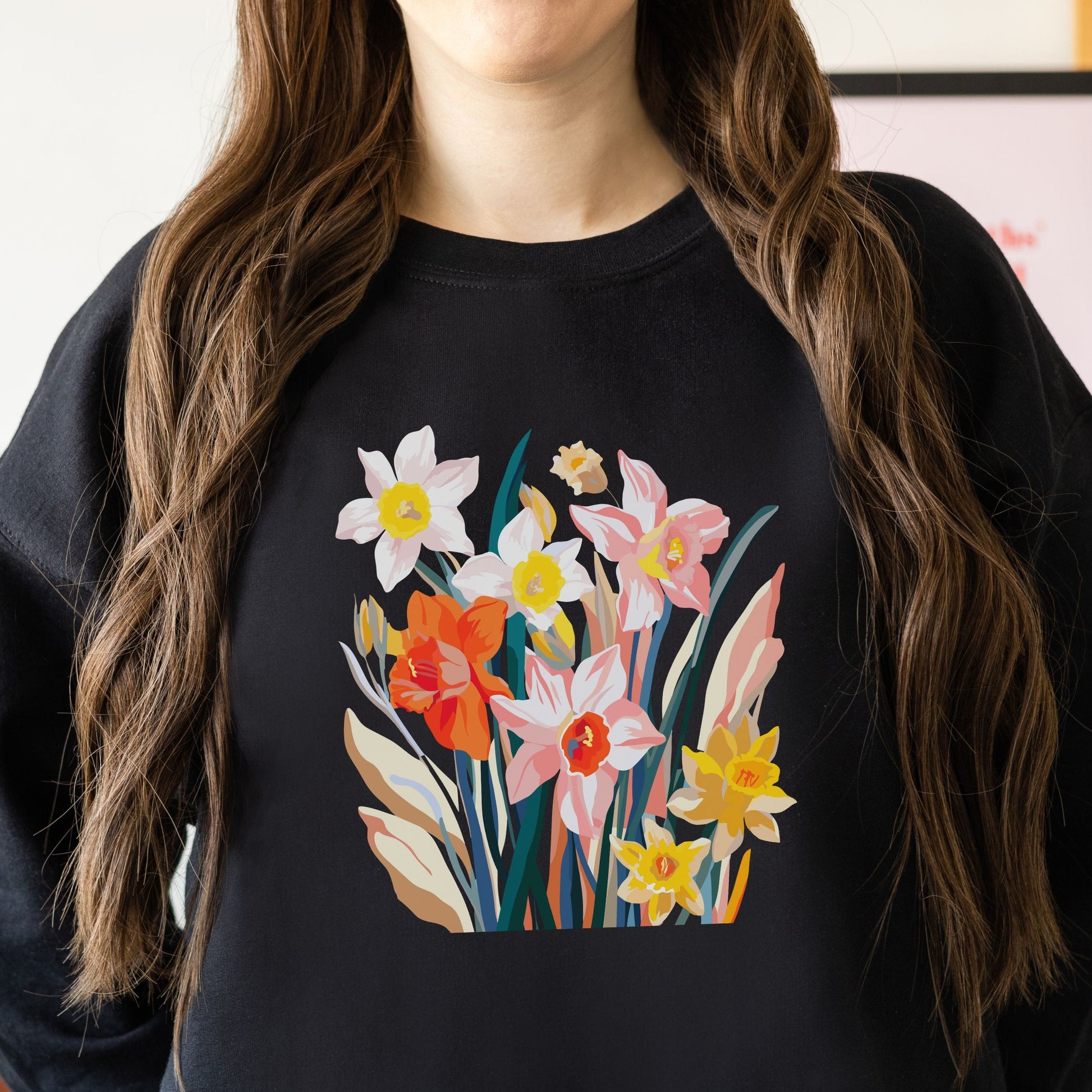 Person wearing a black sweatshirt with a colorful floral design.