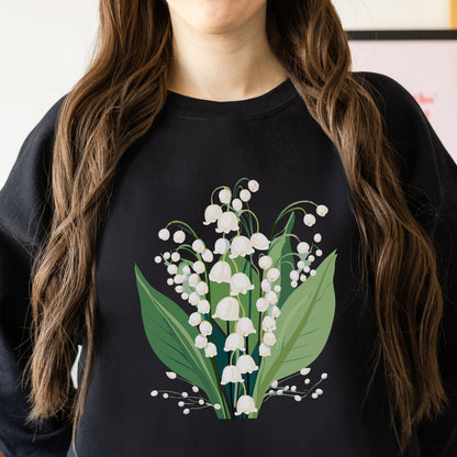 Person wearing a black sweatshirt with a floral design of white flowers and green leaves.