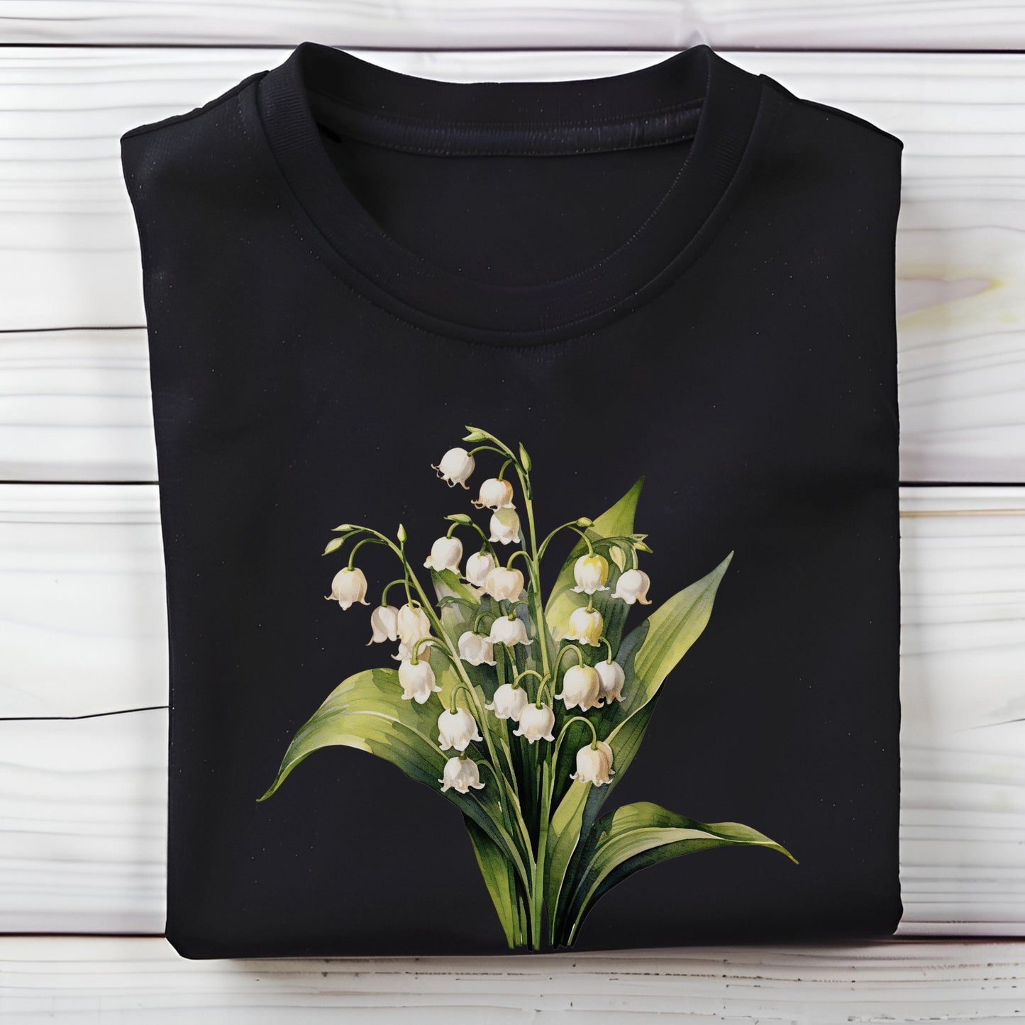 Black shirt with a floral design of lilies of the valley on a wooden surface