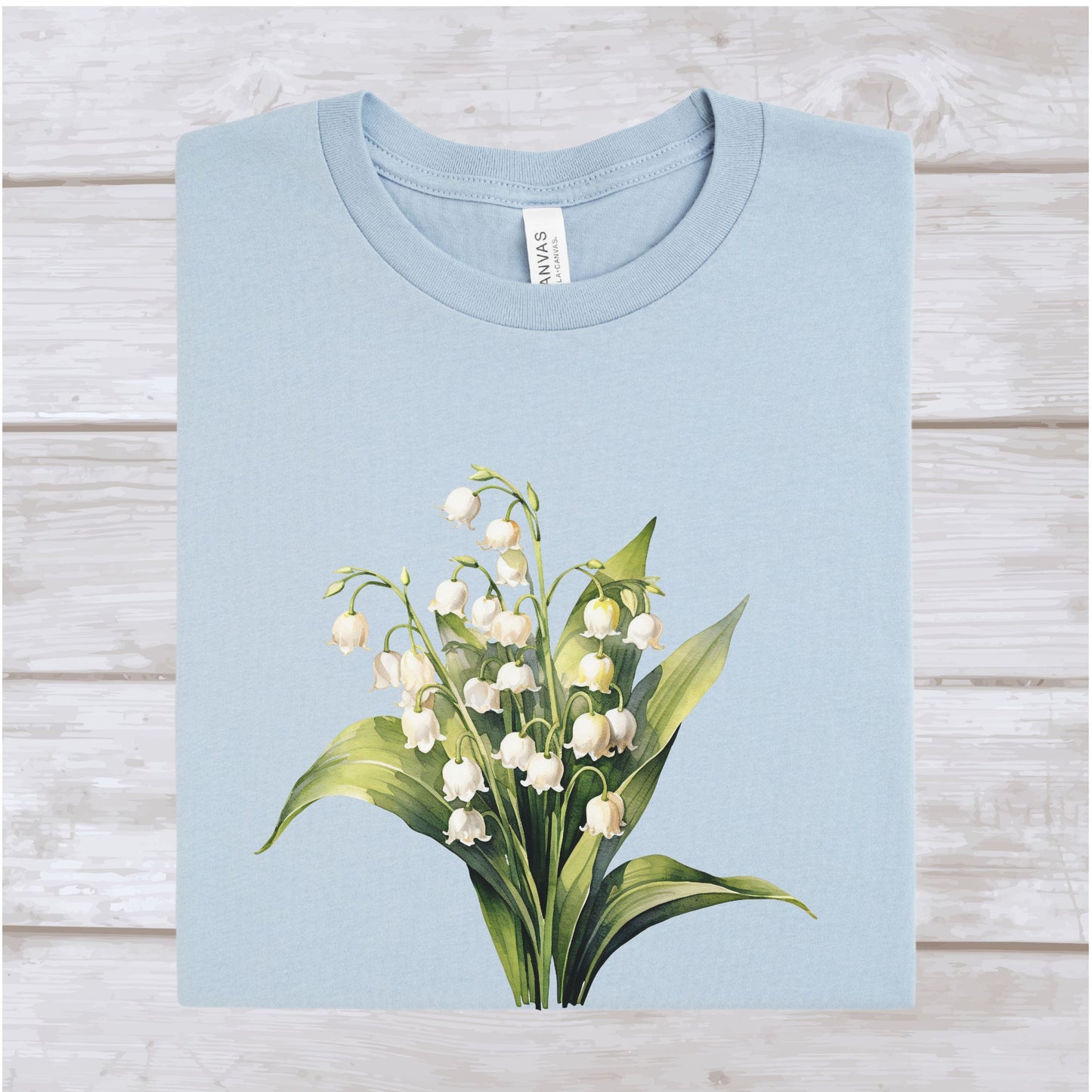 Light blue t-shirt with a floral design on a wooden surface