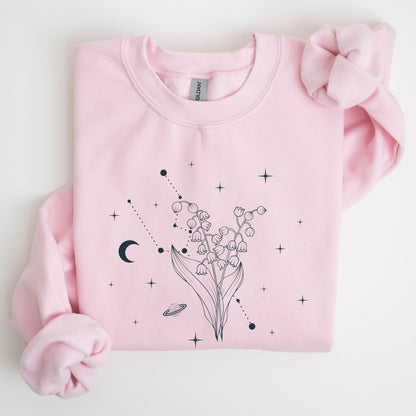 Pink sweatshirt with floral and celestial design on a light gray background