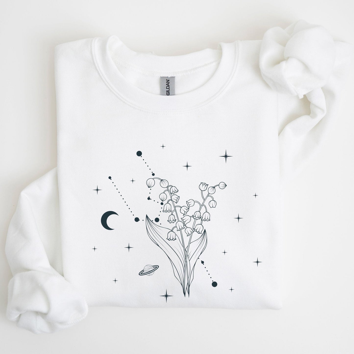 White sweatshirt with black floral and celestial design on a light background