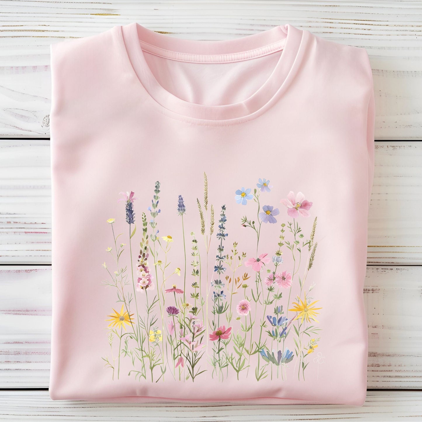Pink t-shirt with floral design on a wooden surface