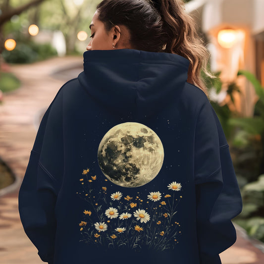 Person wearing a navy hoodie with a moon and floral design, standing outdoors.