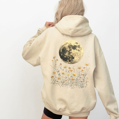 Beige hoodie with a moon and floral design on the back, worn by a person.