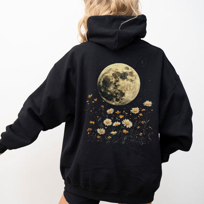Black hoodie with a moon and floral design on the back, worn by a person.