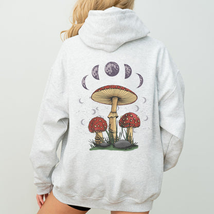 Person wearing a gray hoodie with a mushroom and moon phase design on the back.