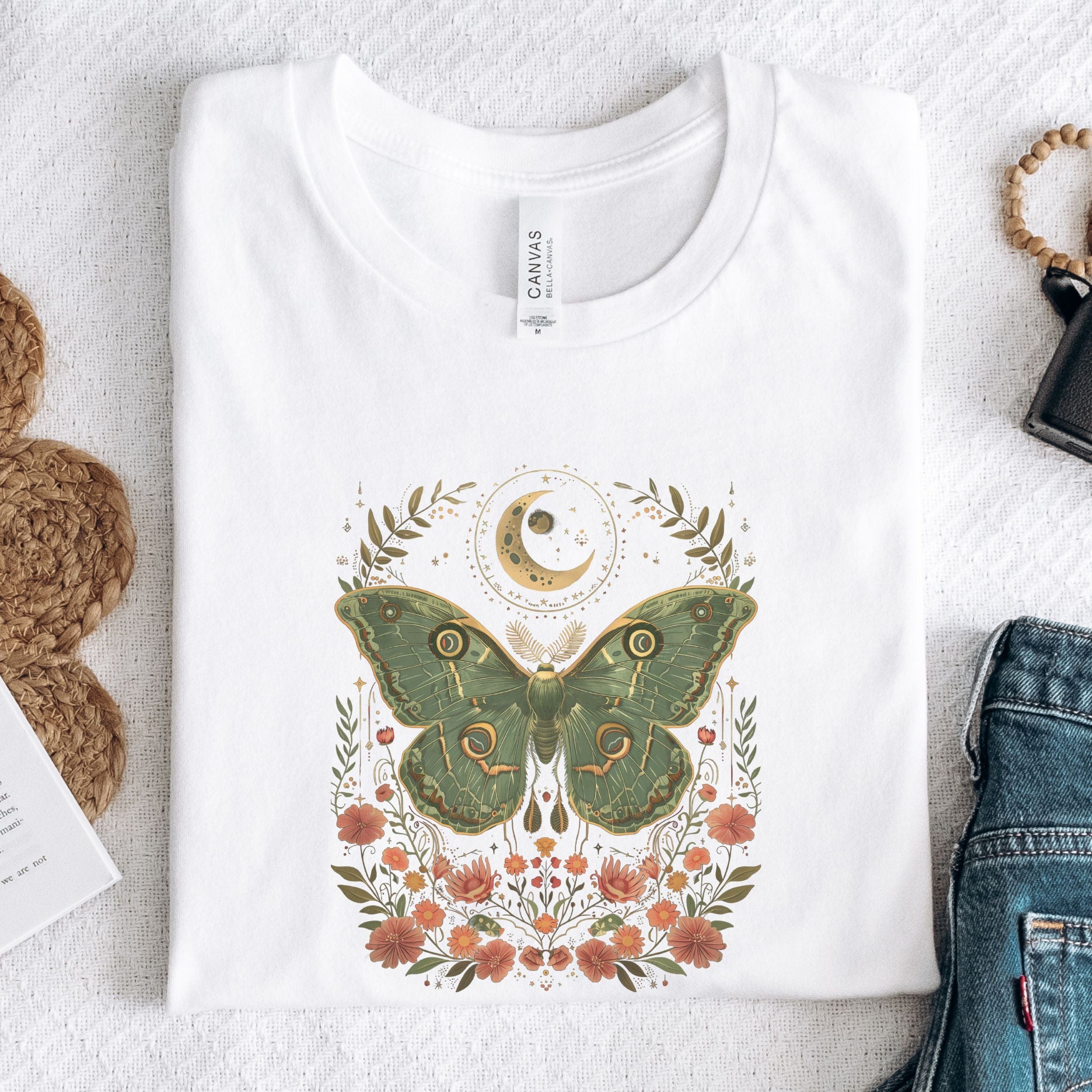 White t-shirt with a moth design on a textured surface