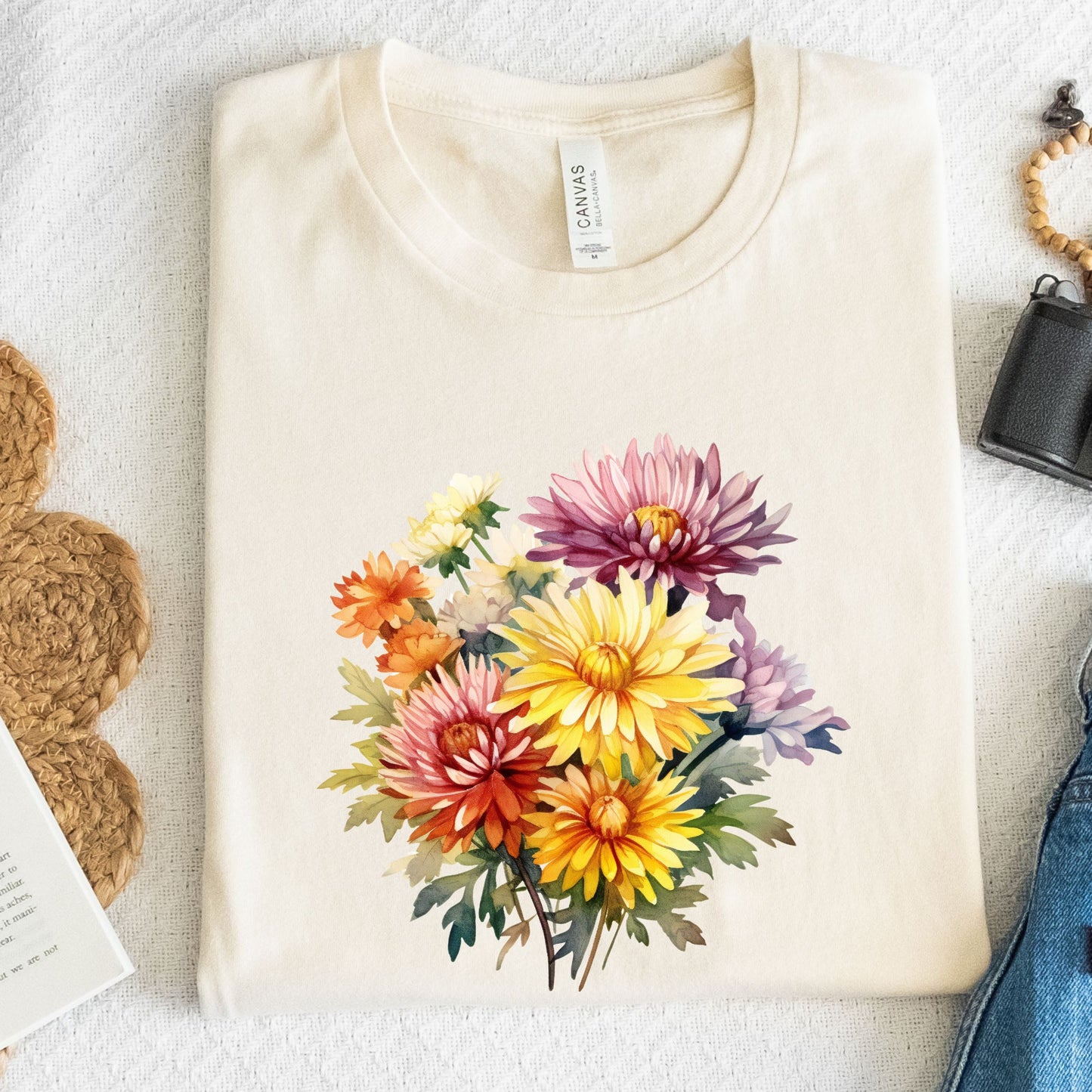 Beige t-shirt with a colorful floral design on a textured surface.
