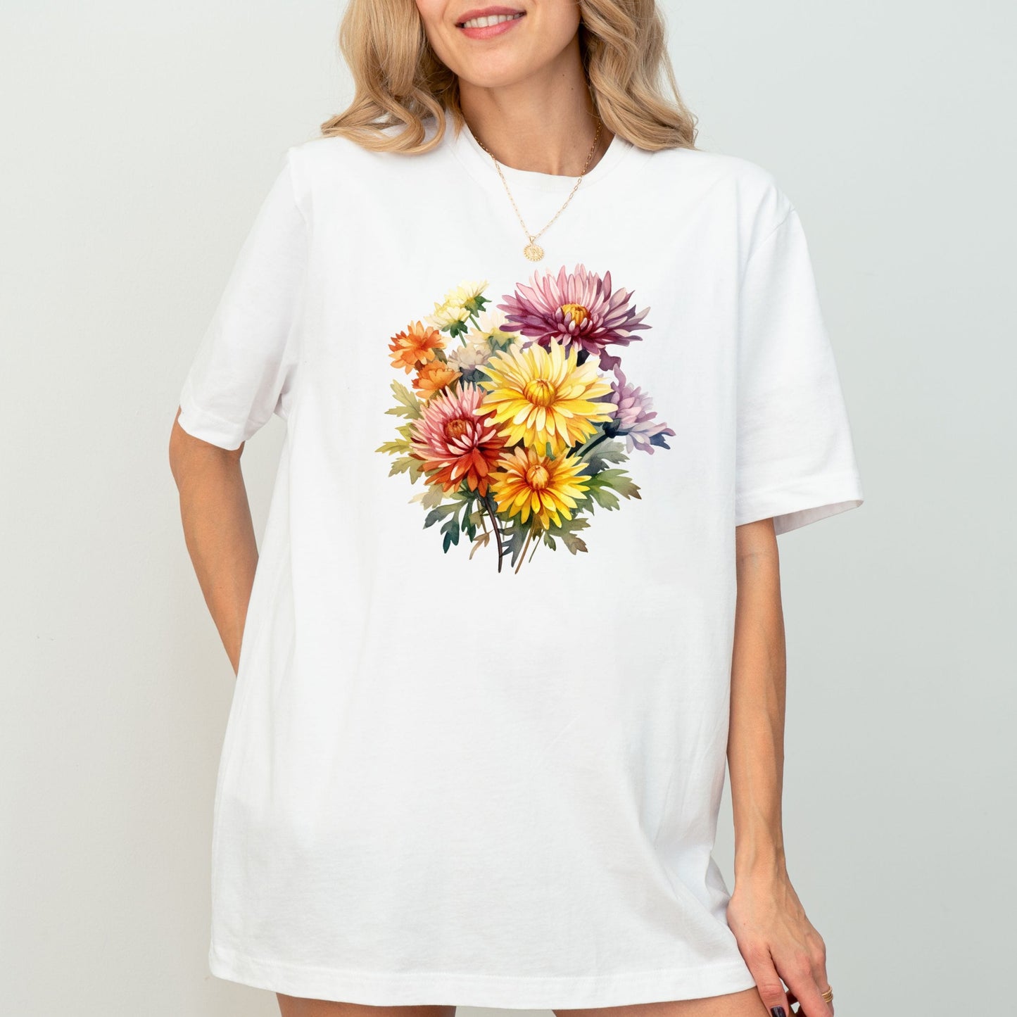 Woman wearing a white t-shirt with a colorful floral design on a plain background