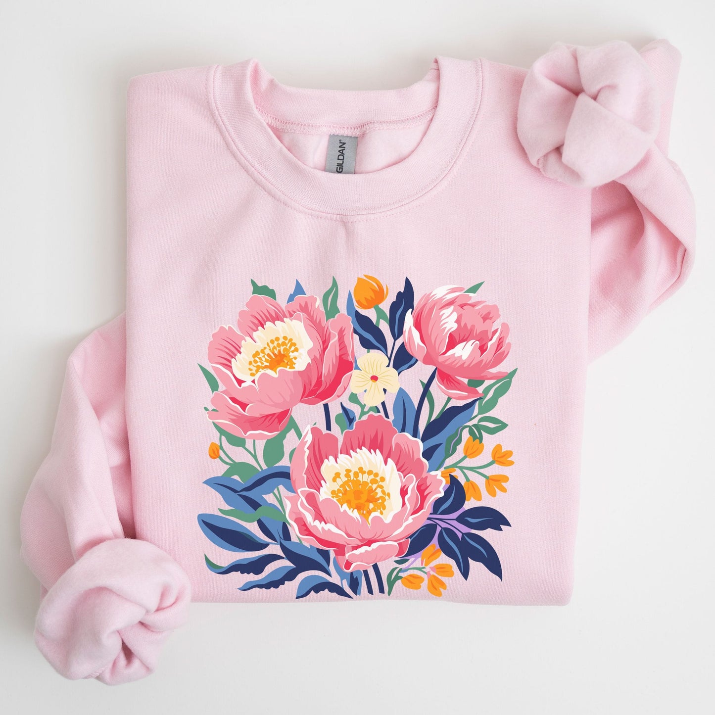 Pink sweatshirt with floral design on a light gray background