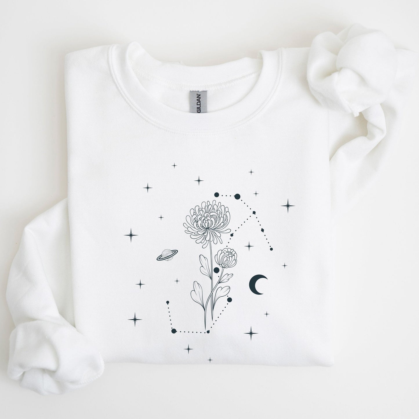 White sweatshirt with black floral and celestial design on a light background
