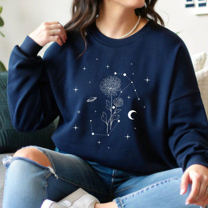 Person wearing a navy blue sweatshirt with celestial design