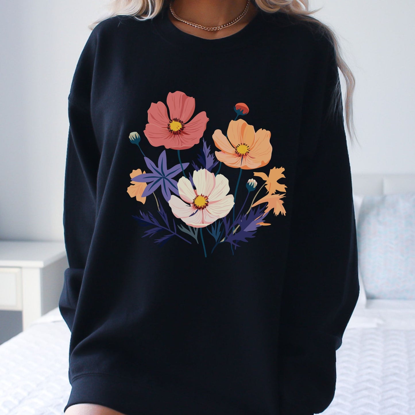 Black sweatshirt with colorful floral design worn by a person.