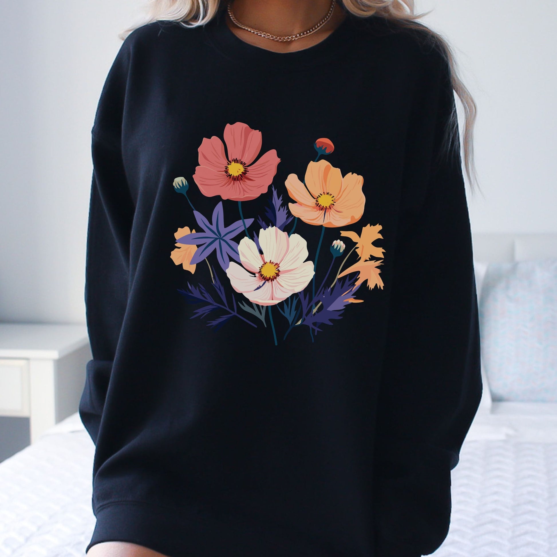 Black sweatshirt with colorful floral design worn by a person.