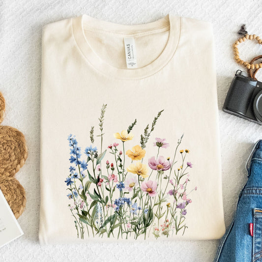 Flat lay of natural t-shirt with pastel watercolor wildflowers