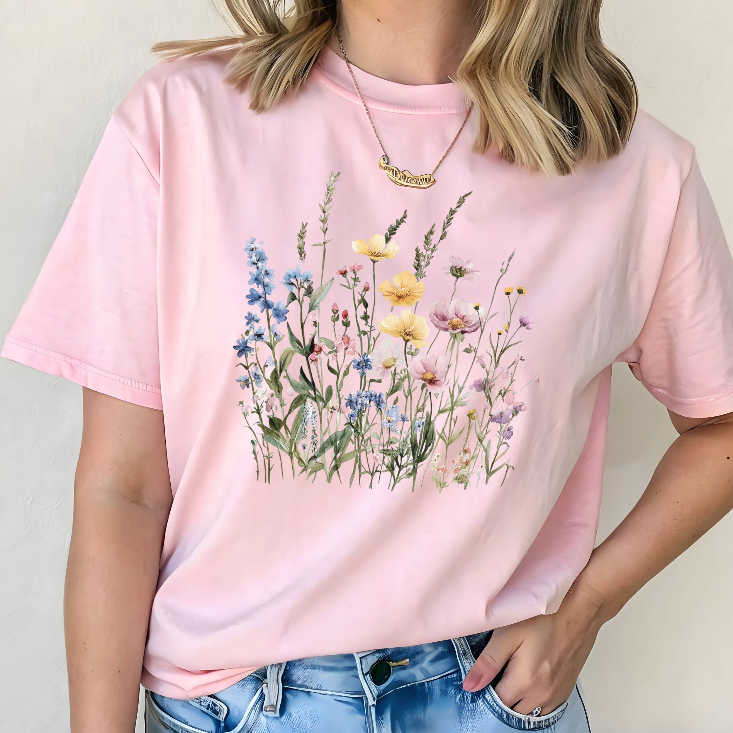 Person wearing a soft pink t-shirt with floral design against a plain background