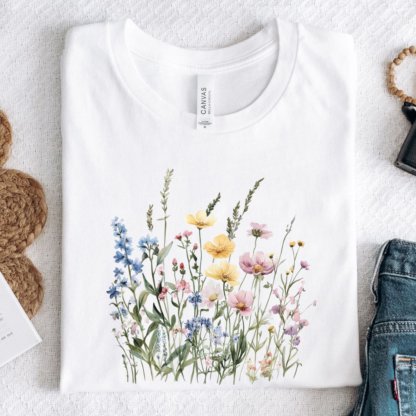 Flat lay of wihite t-shirt with pastel watercolor wildflowers