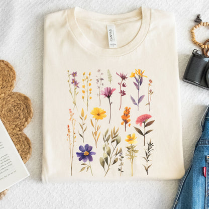 Beige t-shirt with floral design on a light surface with accessories.