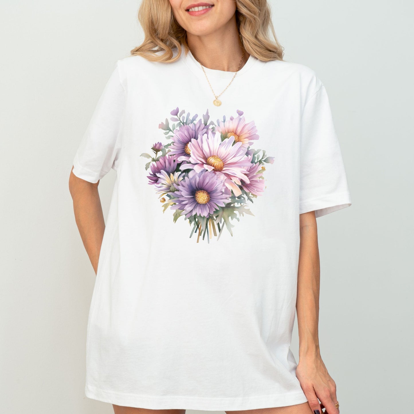 Woman wearing a white t-shirt with a floral design on a plain background