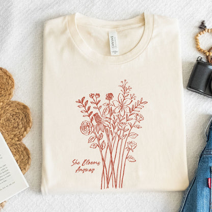 Beige t-shirt with red floral design and text on a textured surface