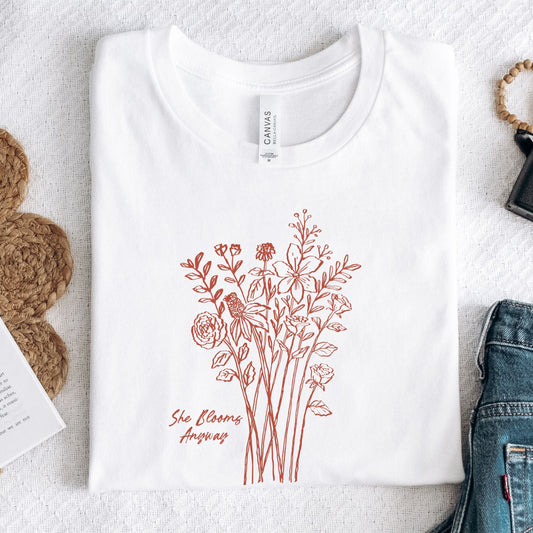 White t-shirt with floral design and text on a textured surface