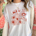 White t-shirt with red graphic design featuring sunflowers, a camera, and text.