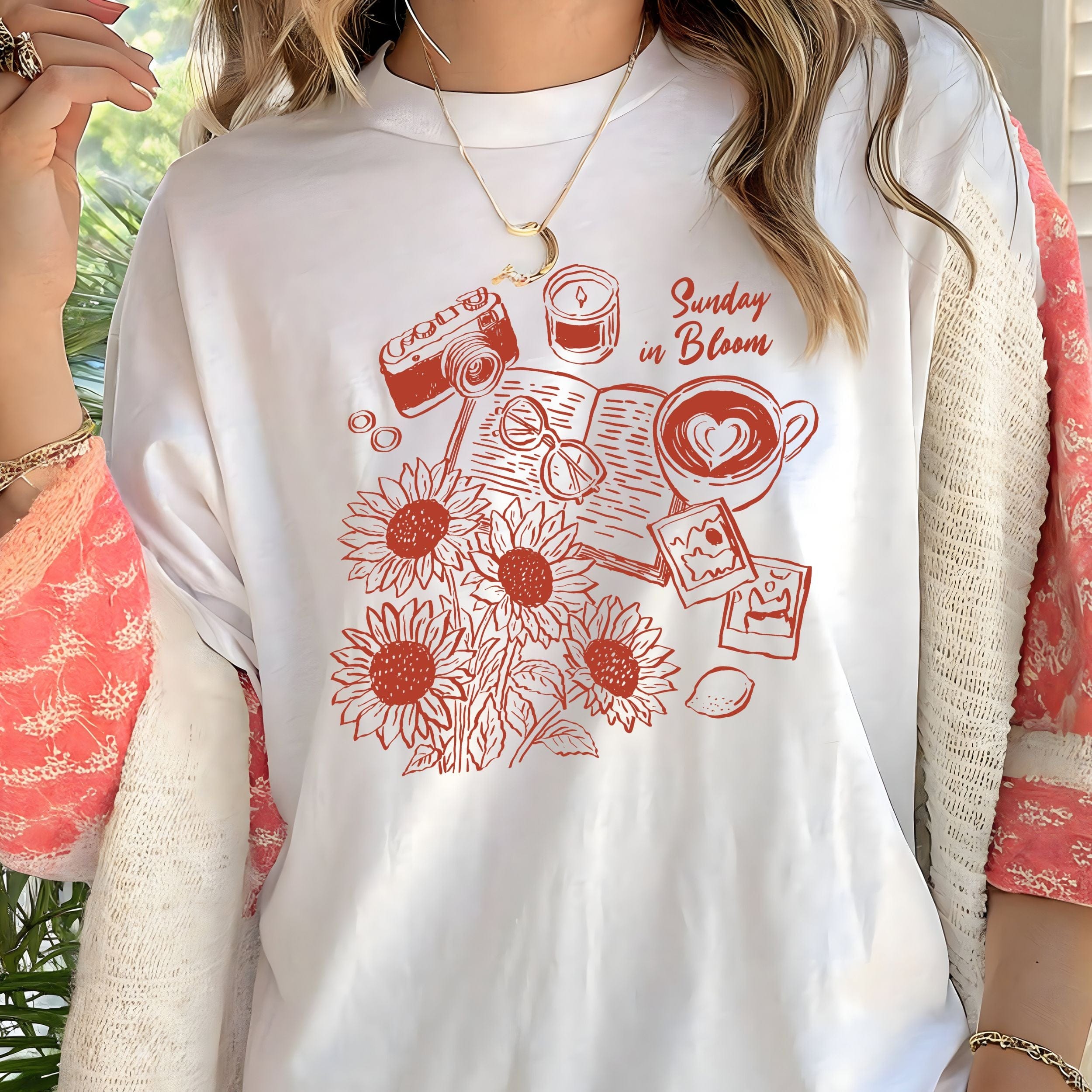 White t-shirt with red graphic design featuring sunflowers, a camera, and text.
