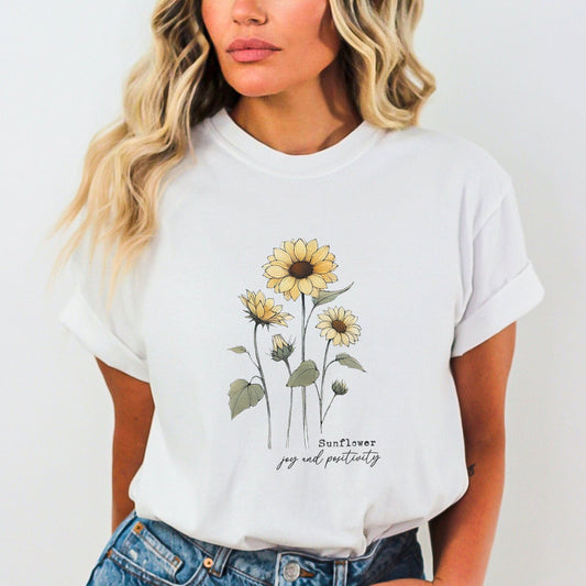 Person wearing a white t-shirt with sunflower design and text.