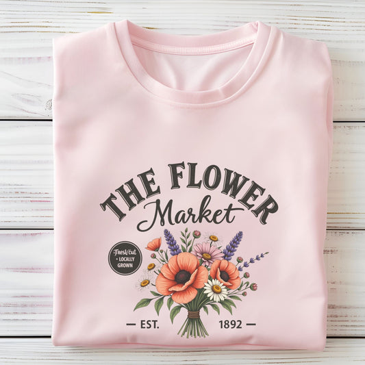 Pink sweatshirt with 'The Flower Market' design on a wooden surface