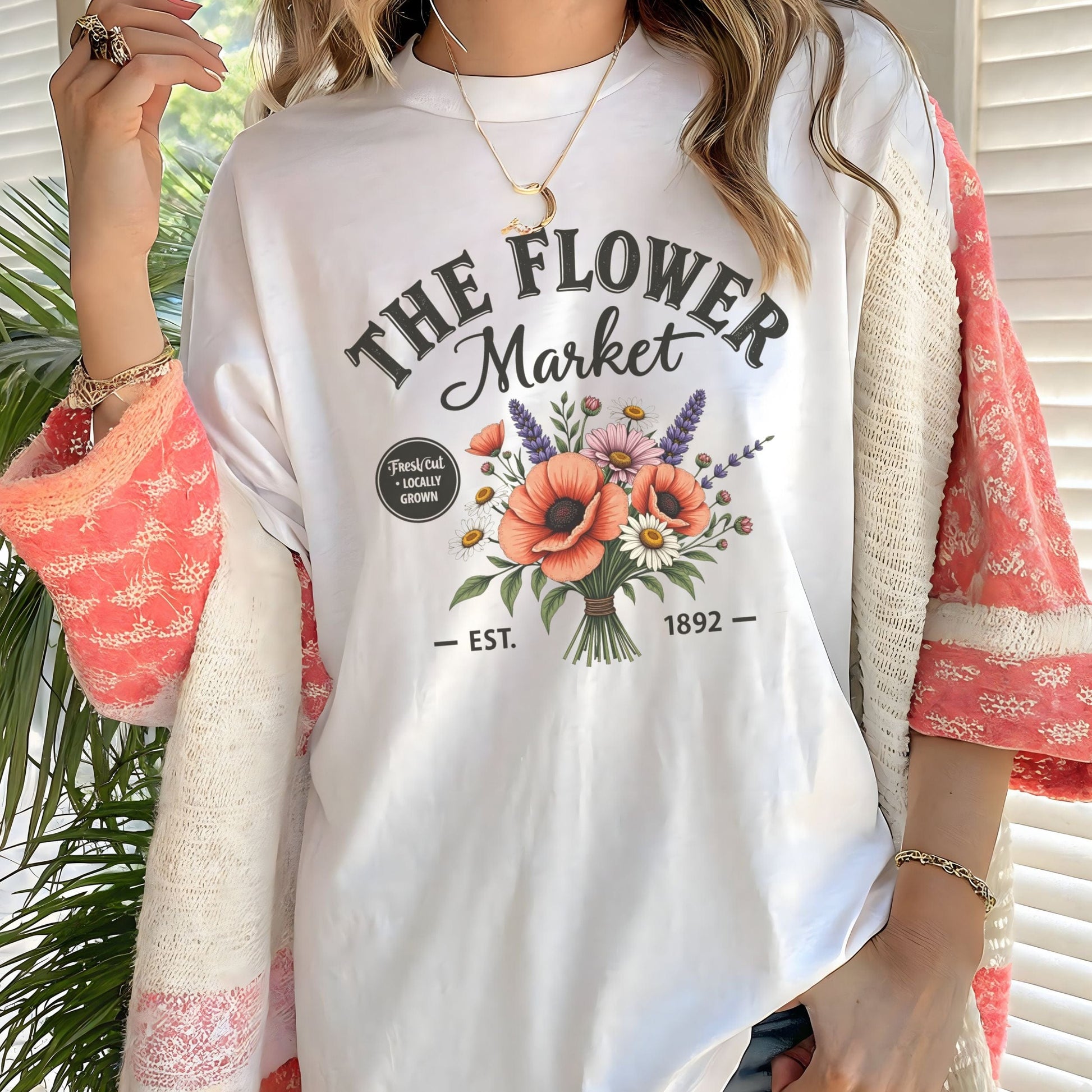 Person wearing a white t-shirt with 'The Flower Market' design and floral elements.