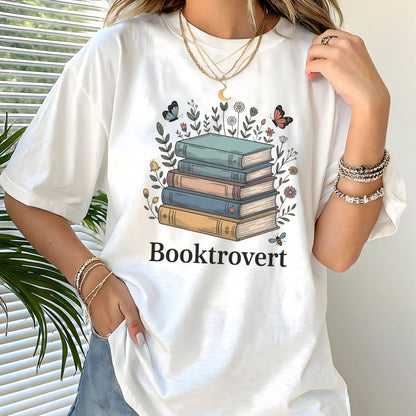 Person wearing a white t-shirt with a book-themed design and 'Booktrovert' text.