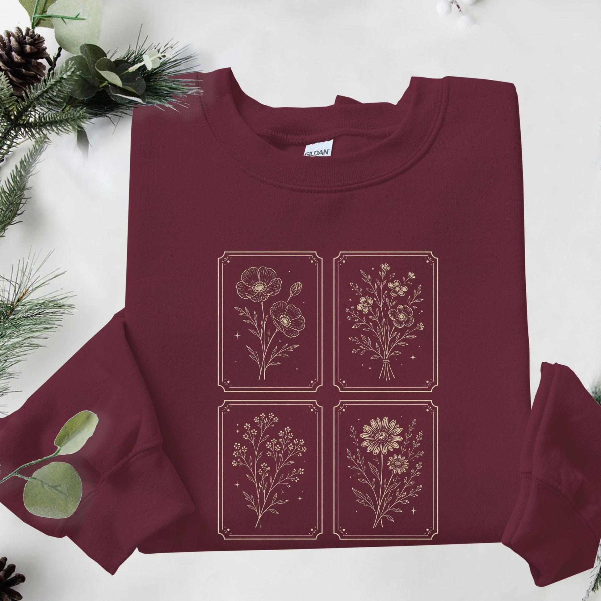 Maroon sweatshirt with floral designs on a white background