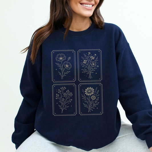 Navy blue sweatshirt with floral designs worn by a person on a white background