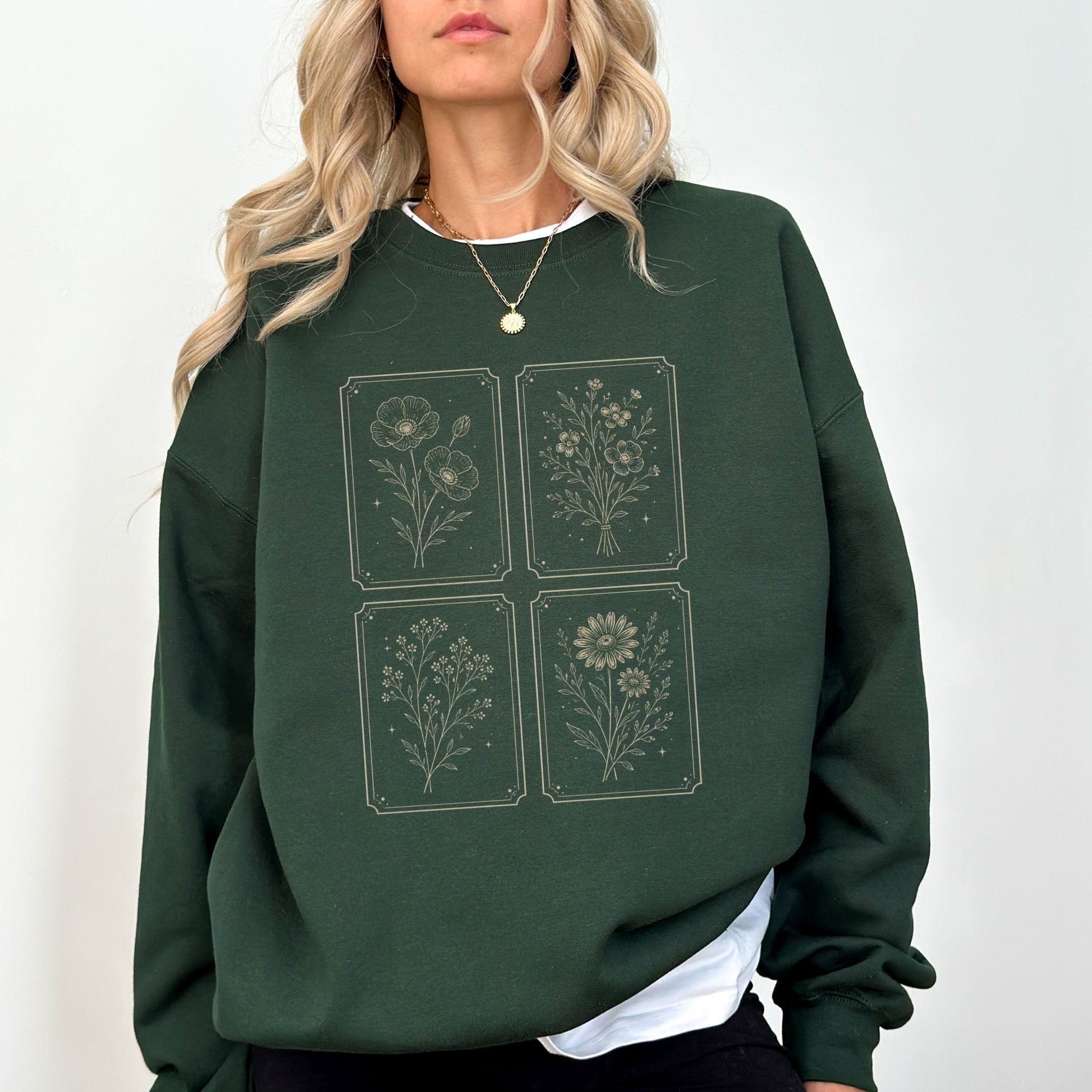 Person wearing a green sweatshirt with floral designs on a white background