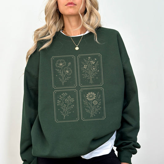 Person wearing a green sweatshirt with floral designs on a white background