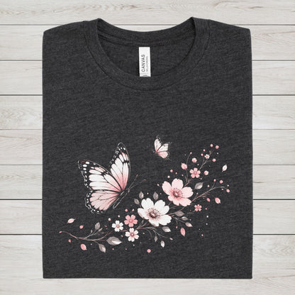Dark gray t-shirt with pink butterfly and floral design on a wooden surface