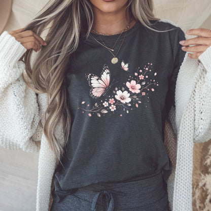 Person wearing a dark gray t-shirt with floral and butterfly design, holding a phone.