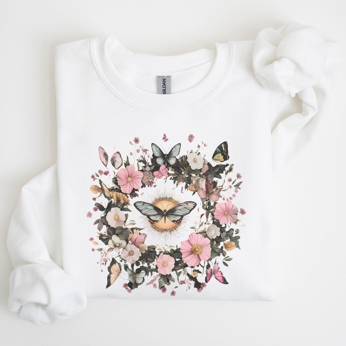White sweatshirt with a floral and butterfly design on a light background